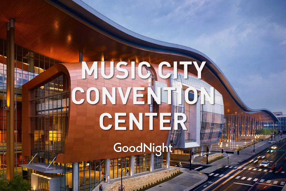 This exterior image showcases the impressive architecture and glass facade of the Music City Center convention center, with its sweeping roofline and bustling urban environment. The setting conveys the energy and scale of a major event venue in downtown Nashville.